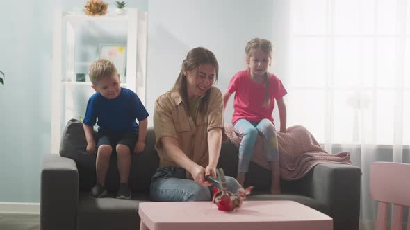 Young Mother with Children Breaks Piggy Bank