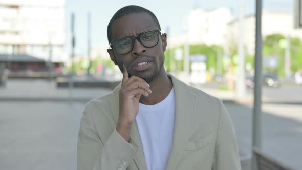 African Man Thinking While Standing Outdoor