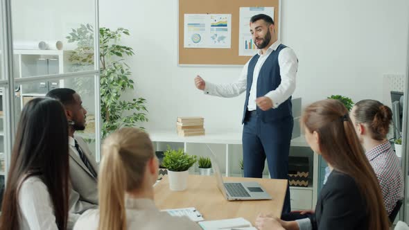 Ambitious Businessman Making Presentation Then Doing Highfive with Group of Colleagues in Office
