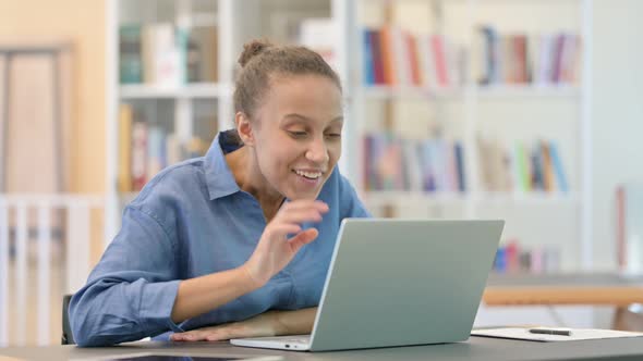 Professional African Woman Doing Video Call on Laptop in Library