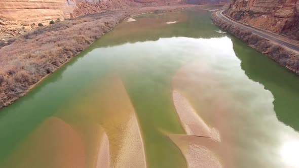 Aerial view flying backwards over sandbar in the Colorado River