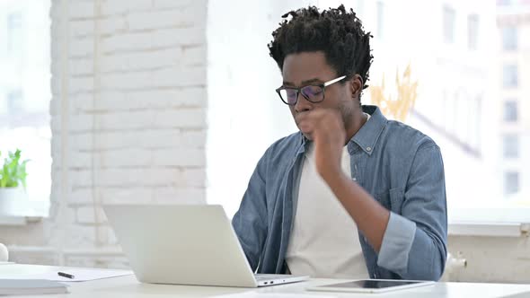 Young African Man Working and Get Tired on Laptop