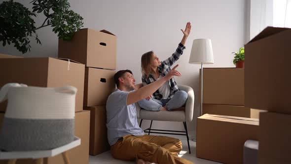 Happy Young Family Discusses a Plan for a New Home Immediately After Relocation