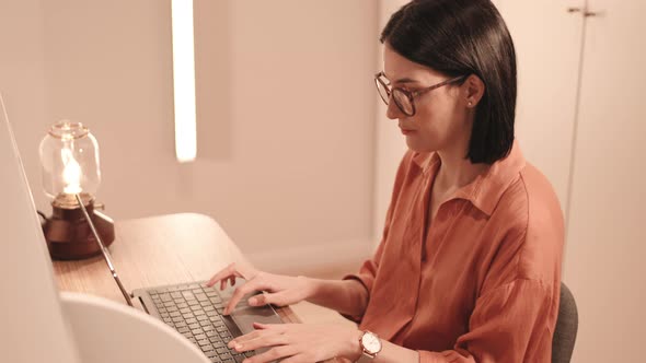 Woman Using Portable Computer by Desk