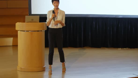 Young Asian businesswoman speaking in speaker on stage in auditorium 4k