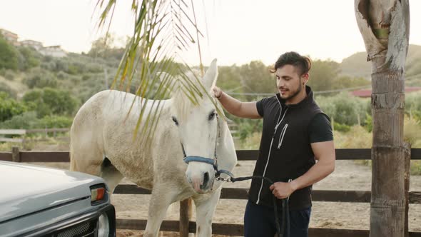 Young Boy Looks After a White Mare on His Private Ranch