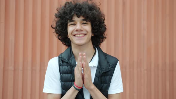 Slow Motion Portrait of Joyful Middle Eastern Teenager Clapping Hands and Smiling Looking at Camera