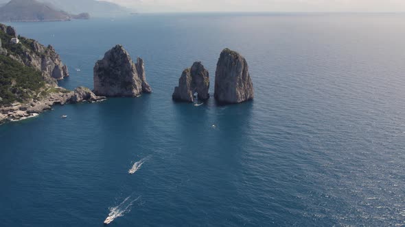 Aerial view of three famous limestone masses (Faraglioni) off Capri coast; drone