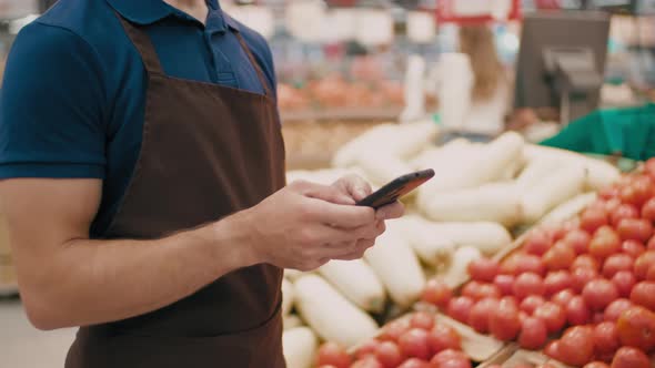 Supermarket Worker Using Smartphone