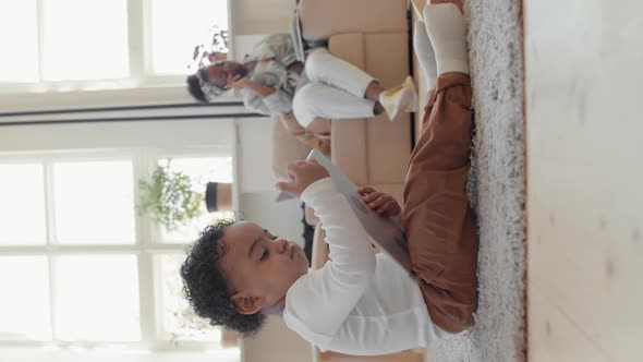 Vertical Shot of Toddler Using Tablet to Entertain Himself