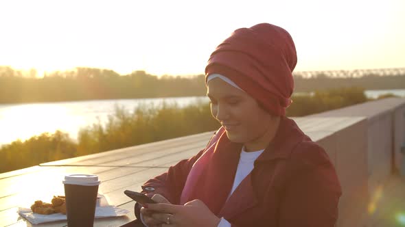 Young Muslim Woman Wearing Hijab Having Coffee Break Outdoor on City Background