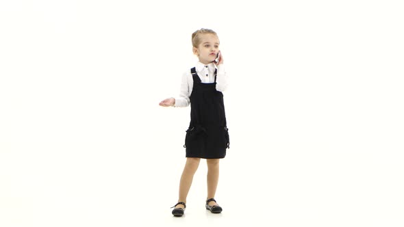 School Girl First Grader Communicates By Mobile Phone, White Background