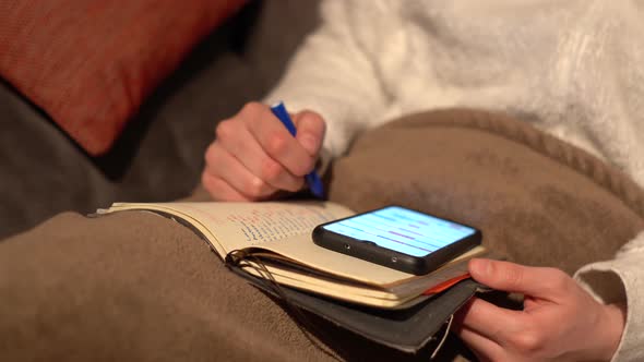 Woman's hand on sofa with mobile and agenda