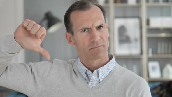 Thumbs Down By Middle Aged Man at Work Looking at Camera