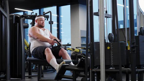 Overweight Funny Man Lifting Blocks Doing Chest Exercises Training on Block Device and Gym Equipment