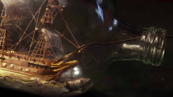 Artisan Painting a Miniature Ship inside a Glass Bottle.
