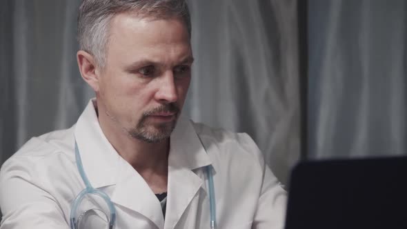 Doctor Working with Laptop at Office in Clinic