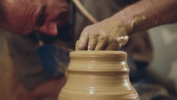 Dirty Potter Making Shape of Prepared Clay Vase in Workshop