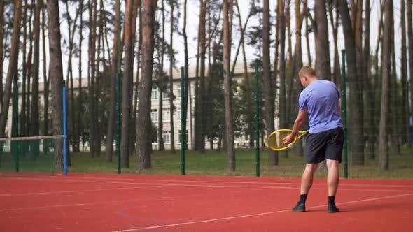 Active Sporty Male Tennis Player Serving a Ball