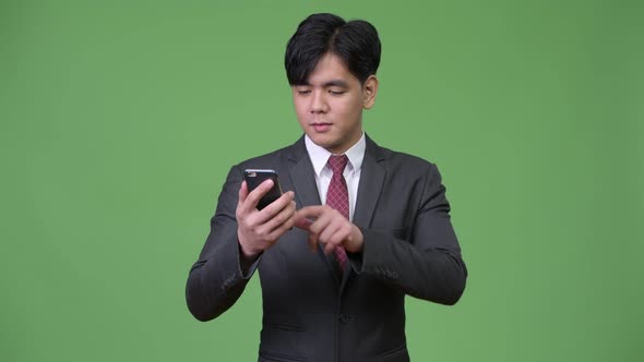 Young Handsome Asian Businessman Using Mobile Phone