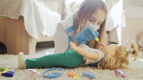 Beautiful Little Girl Playing Doctors with Doll at Home