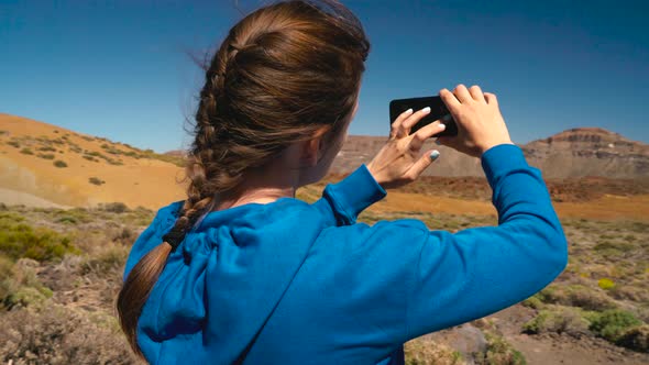 Active Hiker Woman Hiking on Teide National Park and Makes Photo Landscapes on the Smartphone