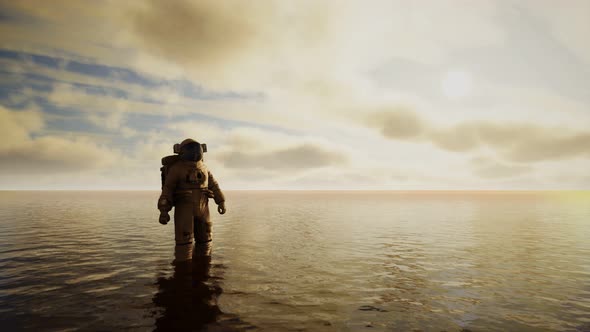 Spaceman in the Sea Under Clouds at Sunset