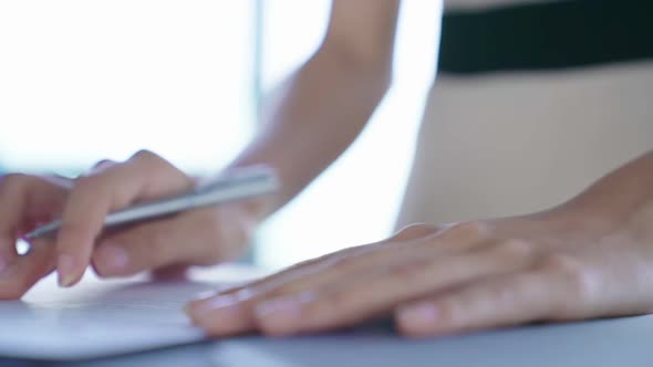 slow motion Mid section of a young asian businesswoman writing, signing documents,contract office