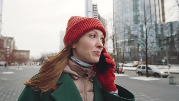 Young Woman Talking on Phone while Walking Outdoors