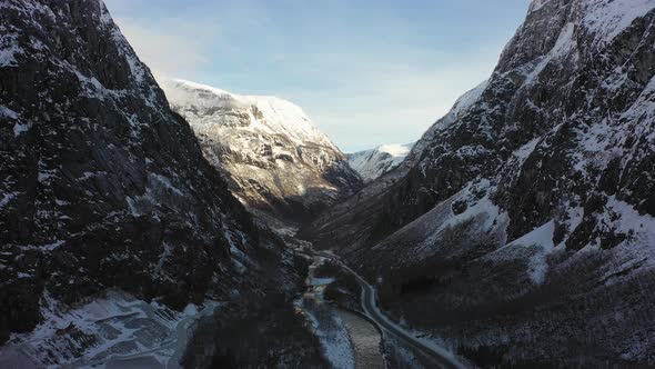 Flying through Naeroydalen valley at morning sunrise - Passing anorthosite mining site close to road