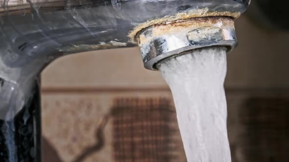 Macro Shot of Faucet with Running Water in Slow Motion