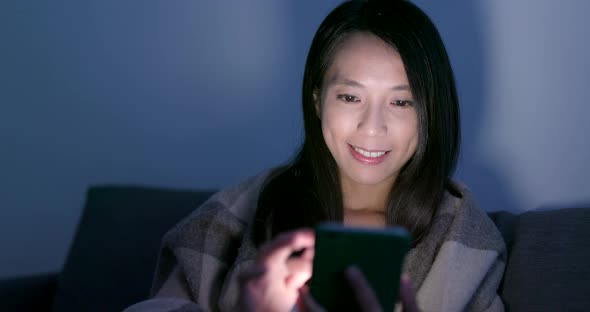 Woman use of smart phone on bed at night