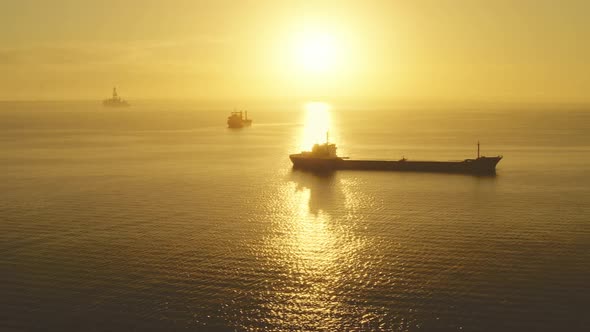 Aerial Dry Cargo Ships in Yellow Sunset Ocean