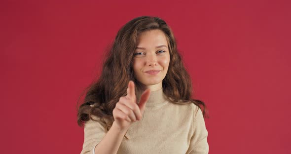 Studio Portrait on Red Background Happy Woman Caucasian Girl Model in Casual Sweater Showing