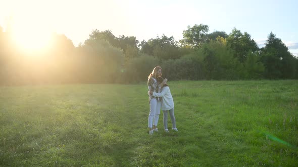 Happy young mum and daughter walking together outdoor enjoy beautiful field