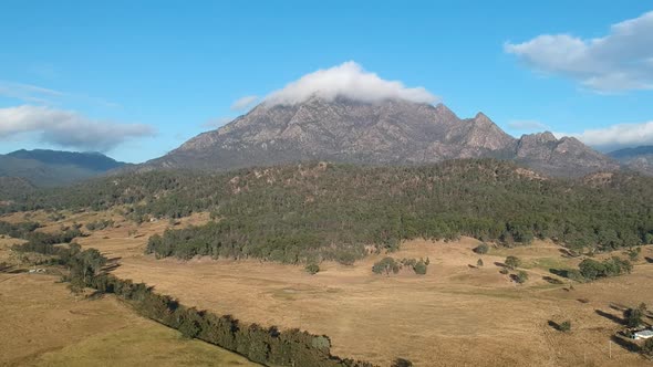 A high view of the rugged Mount Barney Australia  with the summit peak covered in a thick white clou