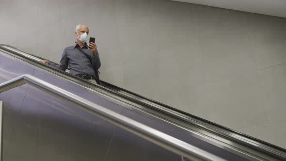 Caucasian man out and about in a metro station wearing on a face mask against coronavirus