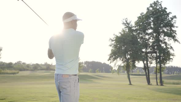 Portrait Handsome Successful Middle Eastern Golfer Swinging and Hitting Golf Ball on Beautiful