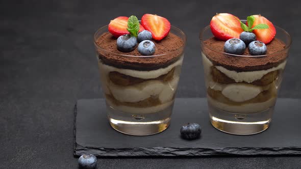 Classic Tiramisu Dessert with Blueberries and Strawberries in a Glass on Stone Serving Board