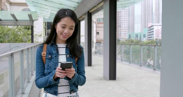 Woman use of smart phone and walking in the street