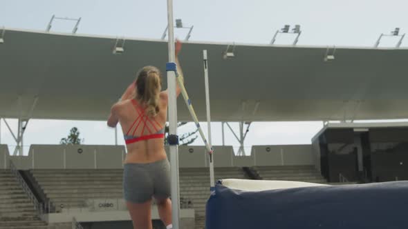 Side view of caucasian athlete doing high jump