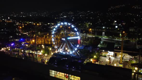 Night view of the city of Medellin, passing through an amusement park on the roof of a mall