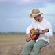 Man Wearing a Straw Hat Playing the Guitar About a Haystack - VideoHive Item for Sale