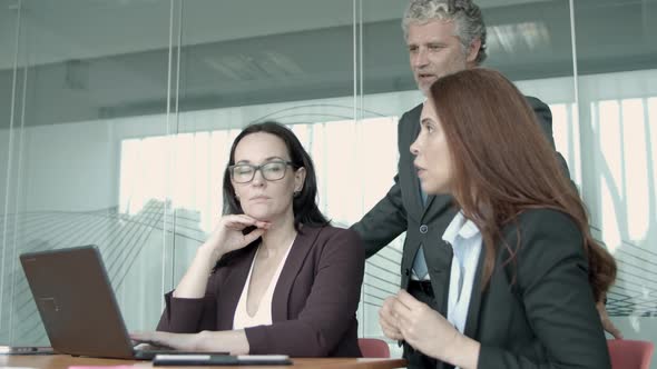 Senior Manager in Glasses Talking with Young Female Employees