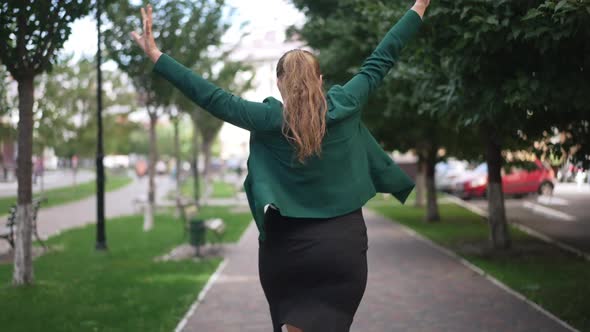 Back View Portrait Cheerful Excited Happy Obese Woman Dancing Rejoicing Walking on Sidewalk Outdoors