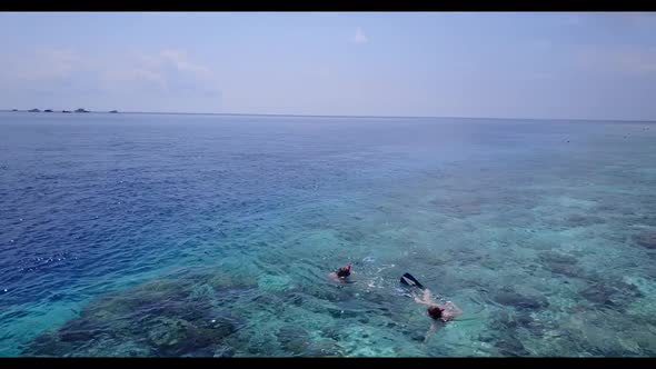 Man and woman suntan on perfect tourist beach wildlife by blue lagoon and white sandy background of 