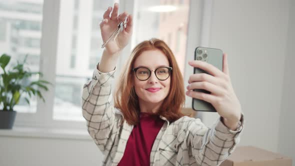 The Student Shows Her Friends the Keys to the Apartment By Video Chat