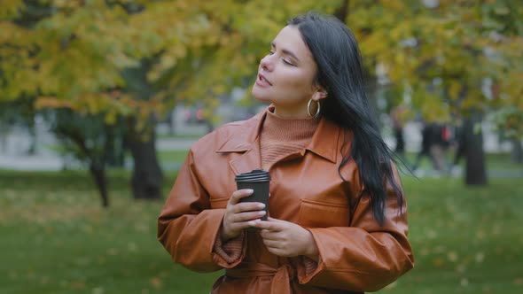 Closeup Young Hispanic Woman Smiling Drinking Coffee From Disposable Cup Outdoors in Autumn Park