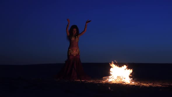 Brunette Dancing Belly Dance Near the Fire, Against a Beautiful Sunset