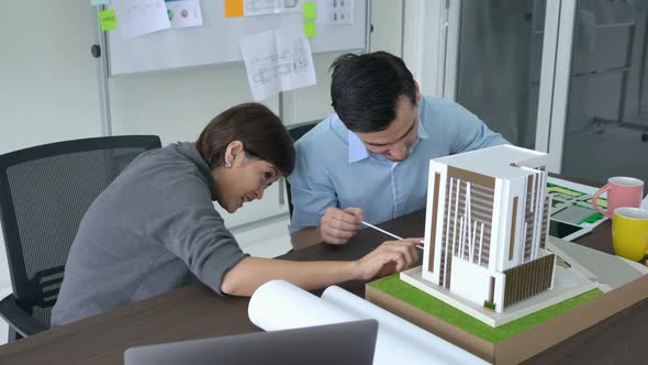 Business people working with building model